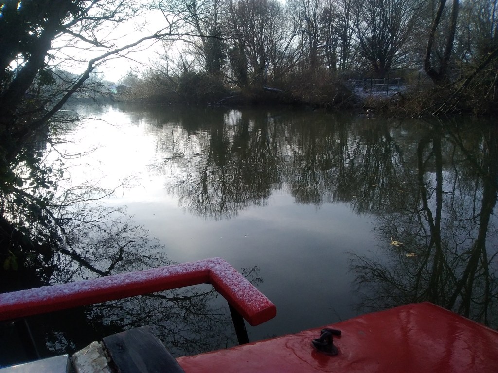 Photo of river from the stern of a narrowboat, winter